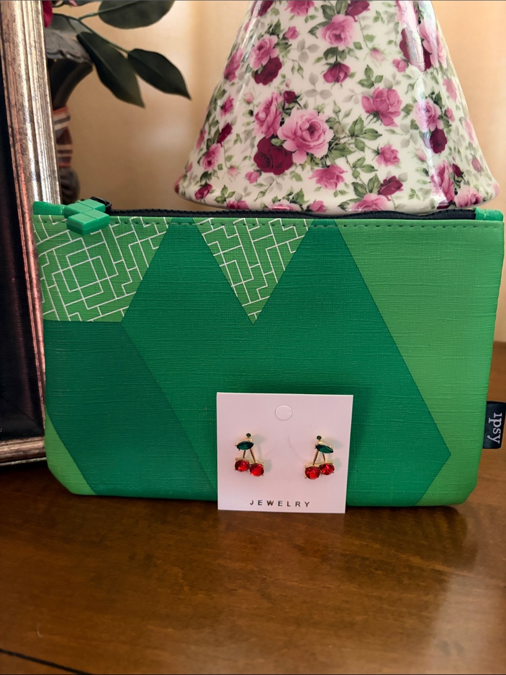 Ipsy green cosmetic bag with cherry earrings